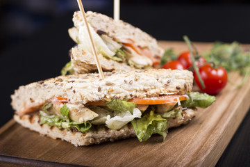 Meat sandwiches with lettuce, tomatoes, and french fries on the side. Beautifully served meal at the restaurant.