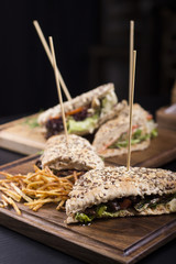 Close up meat sandwiches with lettuce, tomatoes, and french fries on the side. Beautifully served meal at the restaurant.