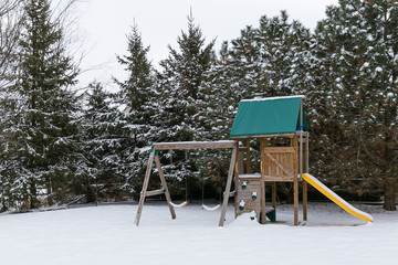 A playset and trees covered in snow