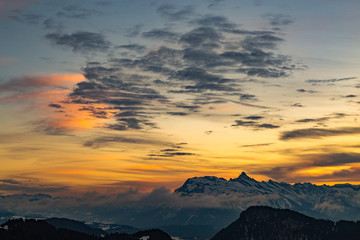 Vibrant orange sunset over snowy mountains