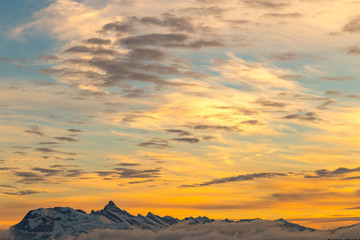 Vibrant orange sunset over snowy mountains