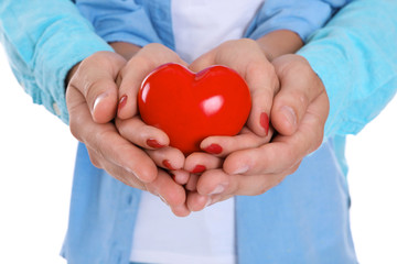Couple with red heart in hands, closeup