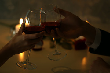 Man and woman hands holding red wine glasses in restaurant
