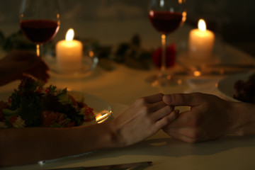 Couple holding their hands in restaurant