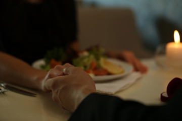 Couple holding their hands in restaurant