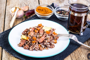 Pilaf with red rice with chunks of beef, carrots and garlic