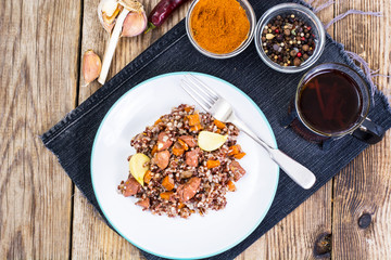 Pilaf with red rice with chunks of beef, carrots and garlic