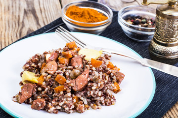 Pilaf with red rice with chunks of beef, carrots and garlic