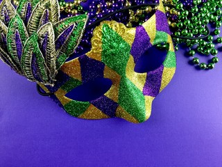 Mardi Gras mask and beads on a purple background  © jlmcanally