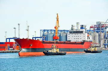 Tugboat assisting bulk cargo ship