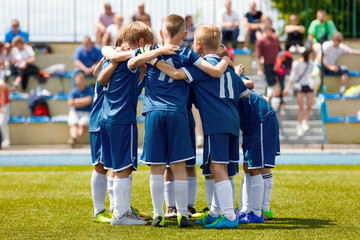 Children's Football Team on the Pitch. Boys in Blue Soccer Kits Standing Together on the Football Field. Motivated Young Soccer Players Before the Final Game of School Tournament