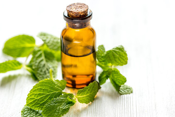 organic cosmetics with herbal extracts of mint on wooden background