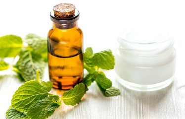 organic cosmetics with herbal extracts of mint on wooden background