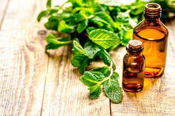 organic cosmetics with herbal extracts of mint on wooden background
