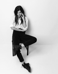 Young beautiful hipster girl sitting in white shirt and modern s