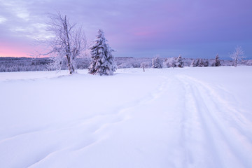 Sunrise over a cold winter landscape with beautiful illuminated clouds