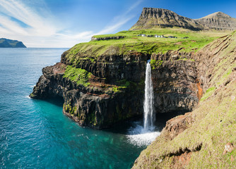 waterfall on faroe islands and the village Gasadalur in background - obrazy, fototapety, plakaty