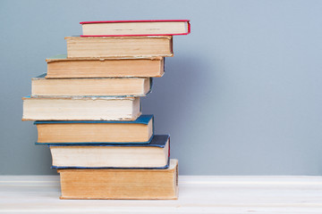 Stack of hardback books on wooden table. Back to school.