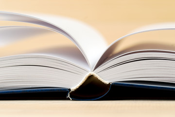 Open book on wooden table.