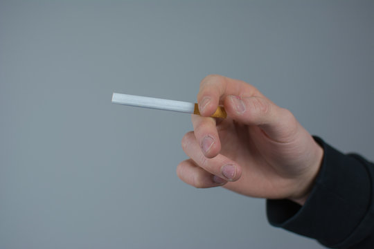 Raucher hält eine Zigarette in der Hand 