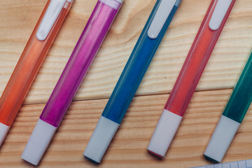 multicolored markers on a wooden background