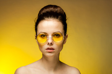 woman in yellow glasses looks at the camera