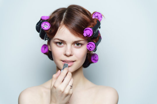 beautiful woman with purple hair curlers on her hair, dye her lips