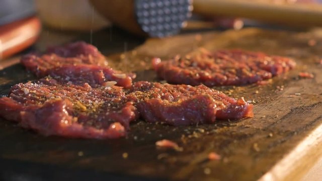 Close up of flavoring meat chops. Slow motion