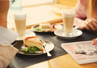 Close up view of young woman sitting in cafe with dessert and drinks
