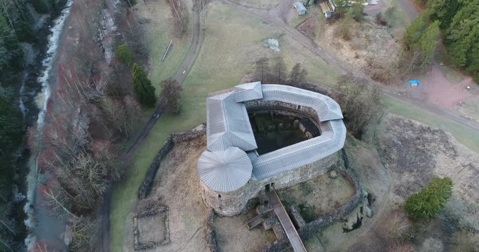 Cinema 4k aerial decending tilit view on Raseborg medieval castle, fortress ruins, at a cloudy autumn day, in Snappertuna, Raasepori, Finland