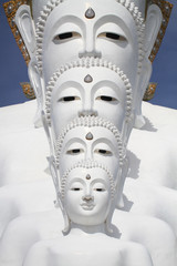 white buddha statue well alignment in front of blue sky and mountain in thailand