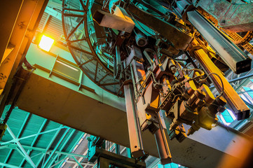 Industrial travelling crane at aluminium plant interior.