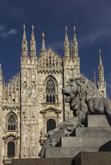 Fototapeta na wymiar A lion figure on a side of Vittorio Emanuele II equestrian statue pedestal in front of Duomo (Cathedral) on Piazza del Duomo of Milan, Italy