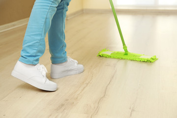 Fototapeta premium Close up view of woman moping floor at home