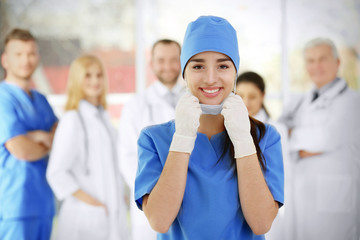 Young female doctor with colleagues in clinic