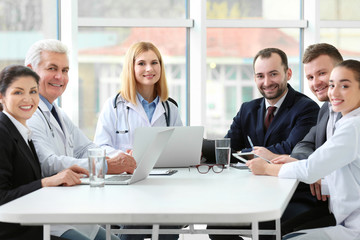 Team of doctors sitting at table in clinic