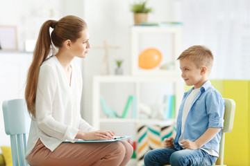 Fototapeta premium Young female psychologist working with little boy in office