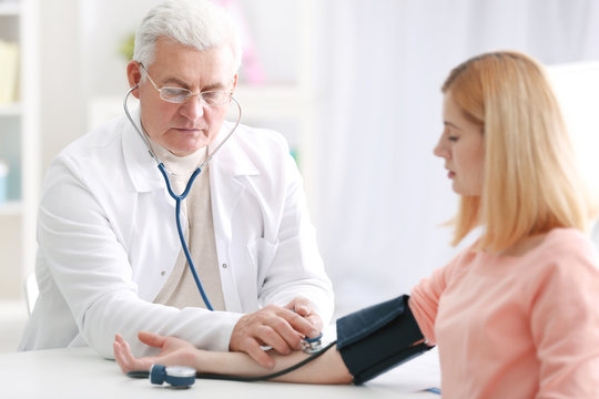 Doctor measuring blood pressure of patient