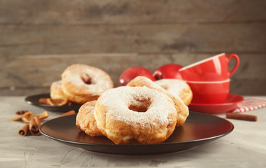 Plate with delicious doughnuts on table