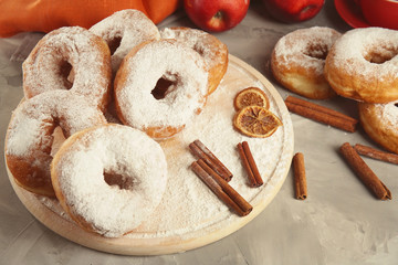 Delicious homemade doughnuts with sugar powder on wooden board