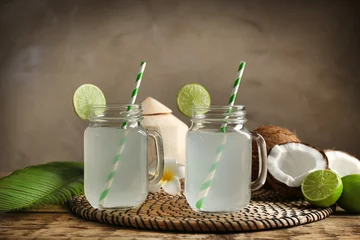 Fototapeten Two mason jars with coconut water on straw mat © Africa Studio