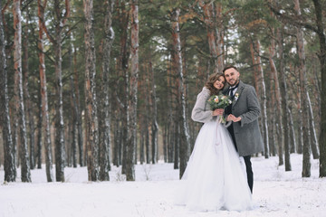 Happy wedding couple outdoors on winter day