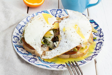 sandwich with egg and vegetables, tea and oranges