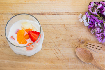 Milk Pudding with fruits in glass on wooden background. Milk Pudding decorate dessert bowl set on Wooden Table .