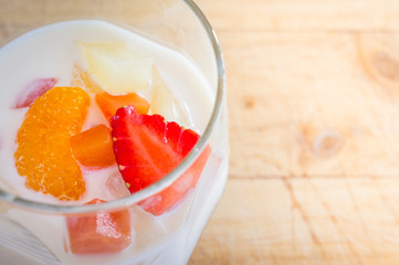 Milk Pudding with fruits in glass on wooden background. Milk Pudding decorate dessert bowl set on Wooden Table .