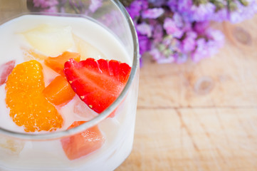Milk Pudding with fruits in glass on wooden background. Milk Pudding decorate dessert bowl set on Wooden Table .