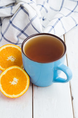tea and oranges on white table