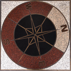 compass direction on the floor in train station.