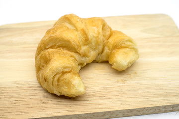 plain croissant on wood plate.