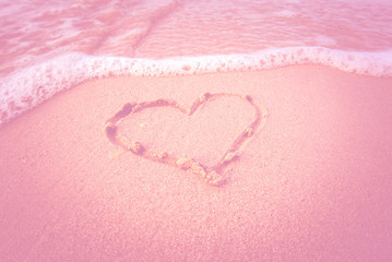 Drawn heart on beach. filtered pink style